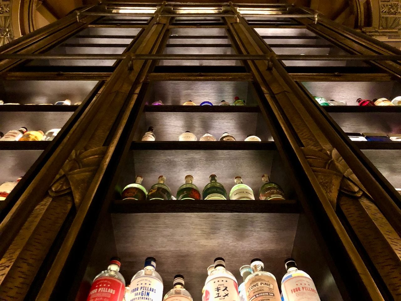 Gin bottles displayed in a tall cabinet at Atlas