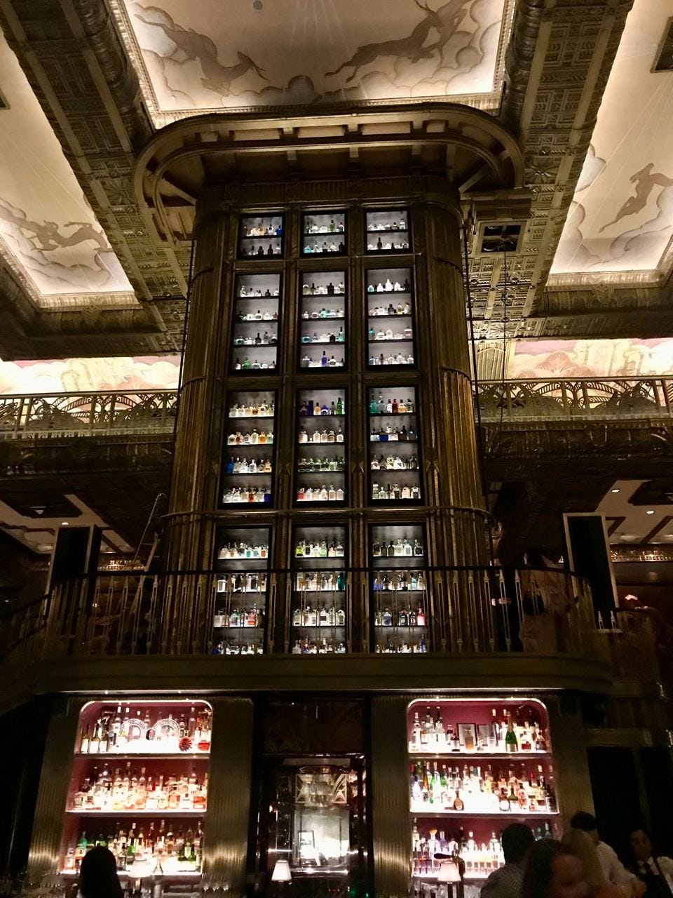 Floor-to-ceiling bottle cabinet inside Atlas Bar