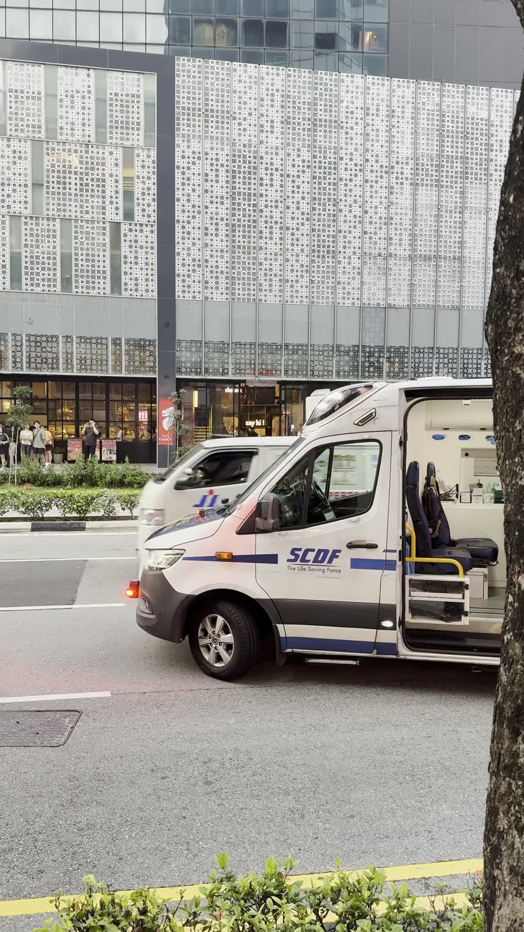 An SCDF ambulance beside Middle Road, with its side door open.