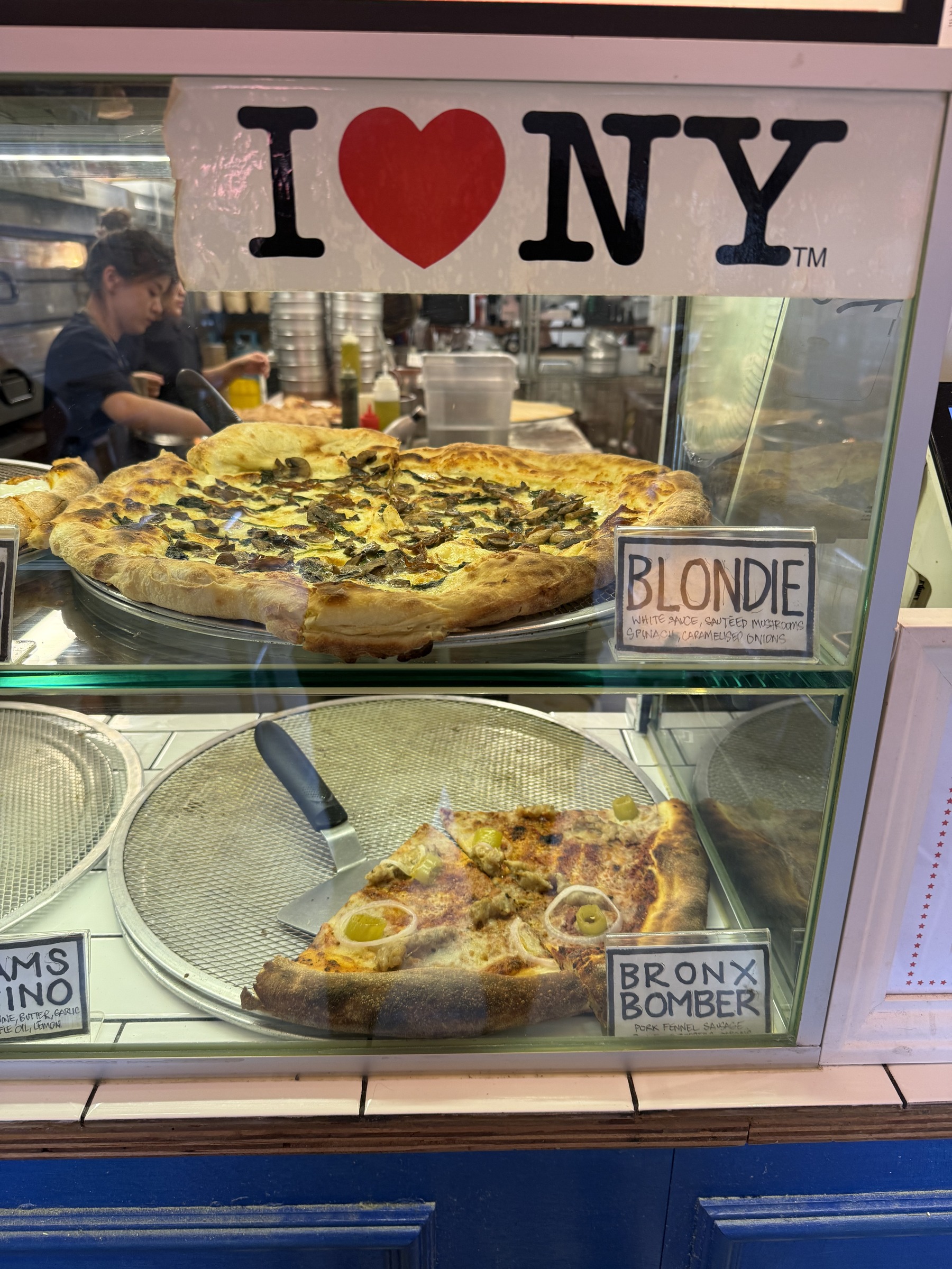 Blondie mushroom pizza and Bronx Bomber slices beneath an I Love NY sign at Choice Cuts