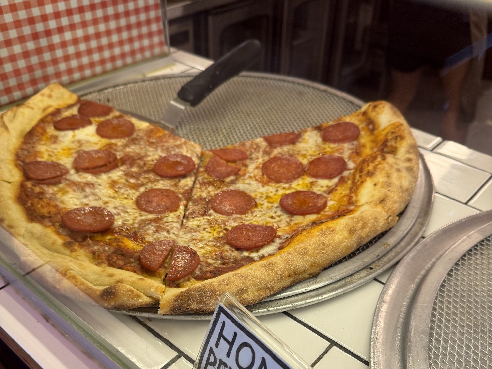 Homie Pepperoni slices in the display at Choice Cuts Pizza & Records