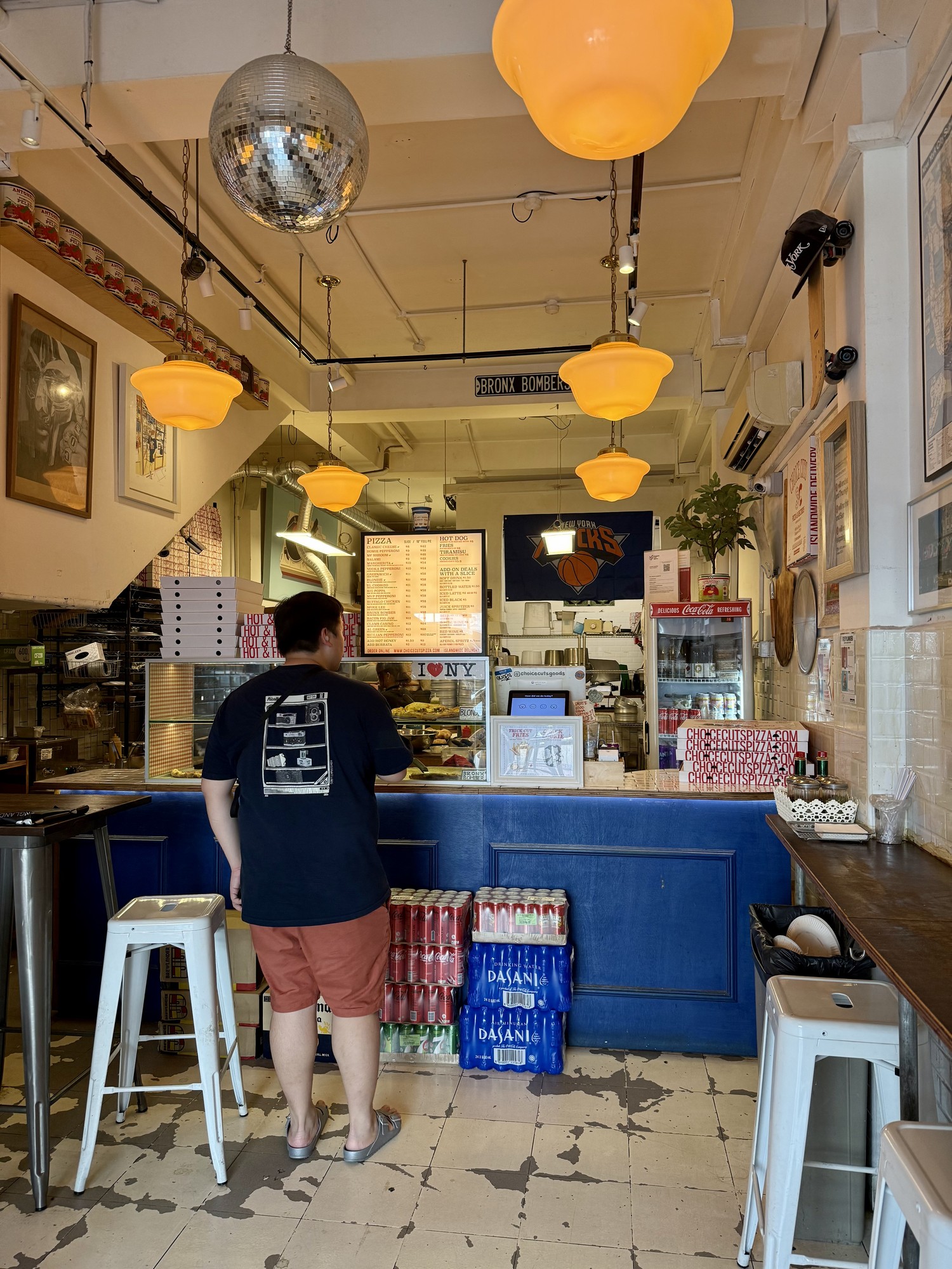 Blue counter, orange pendant lights, disco ball and worn floor inside Choice Cuts