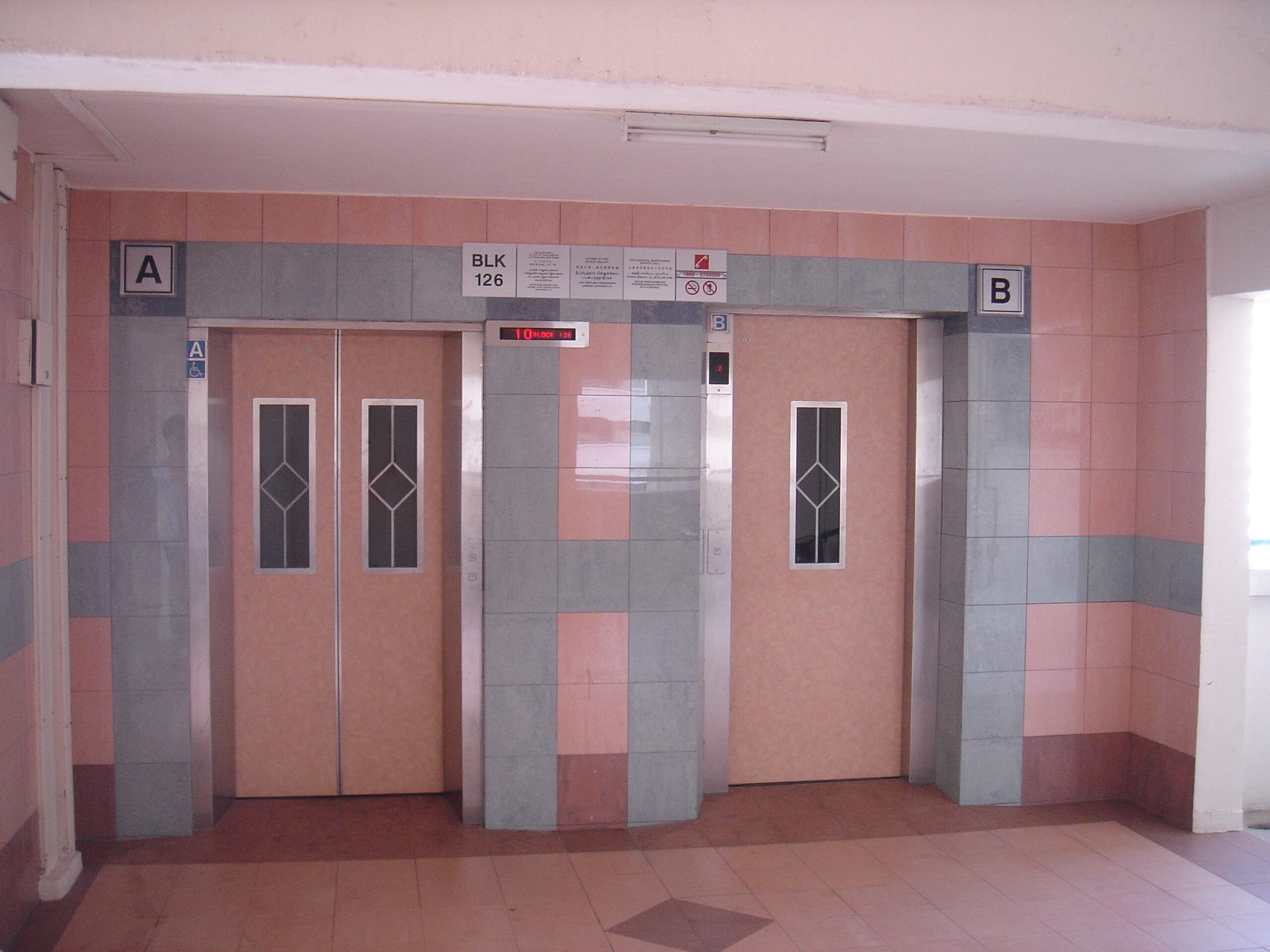 HDB lifts A and B at Block 126, with windowed doors, floor indicators and notice panels