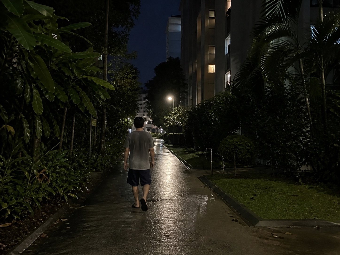 A person walking through a humid Singapore residential estate before dawn