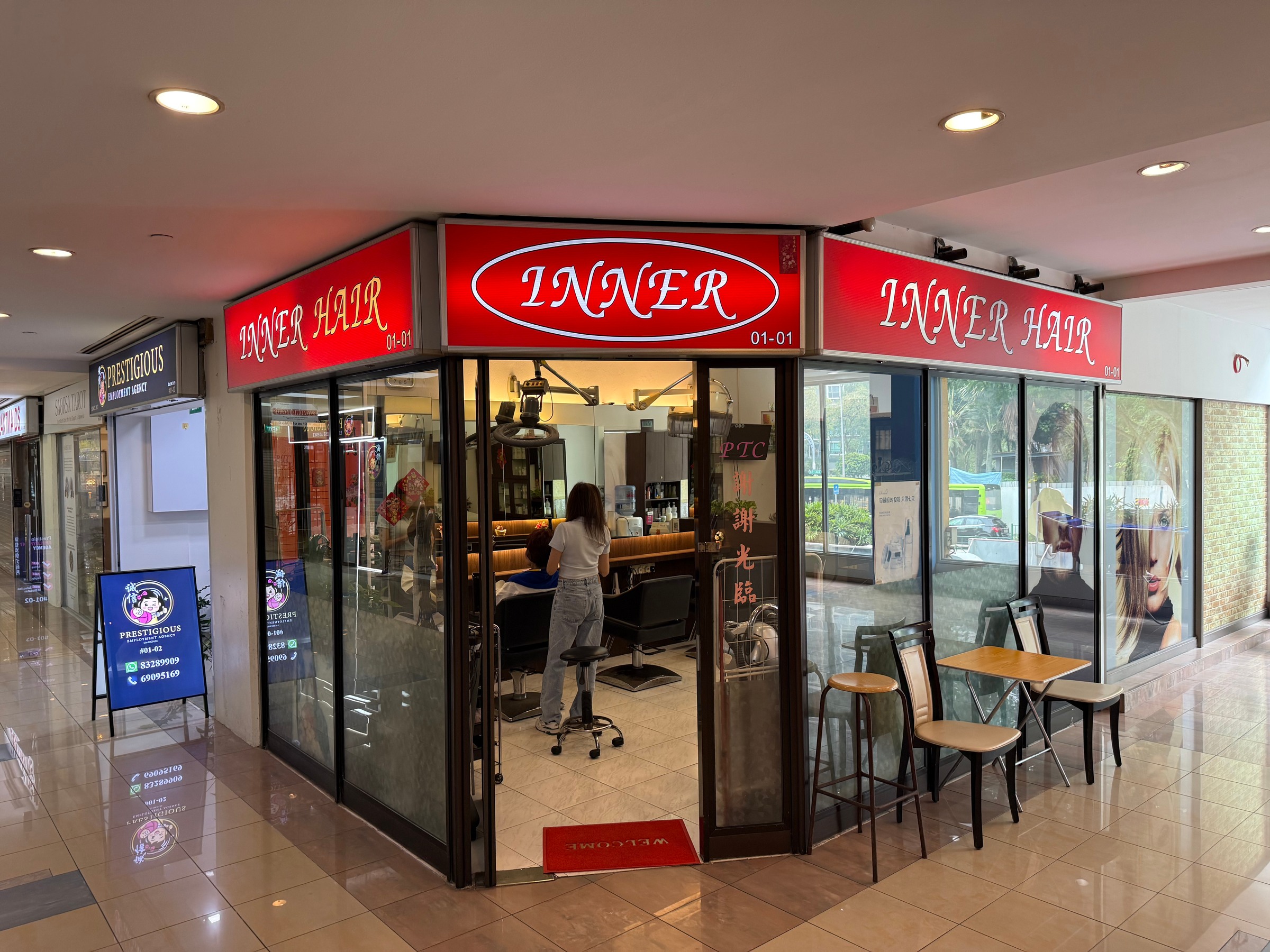 The red Inner Hair sign above a corner salon, with chairs and mirrors visible through the windows.