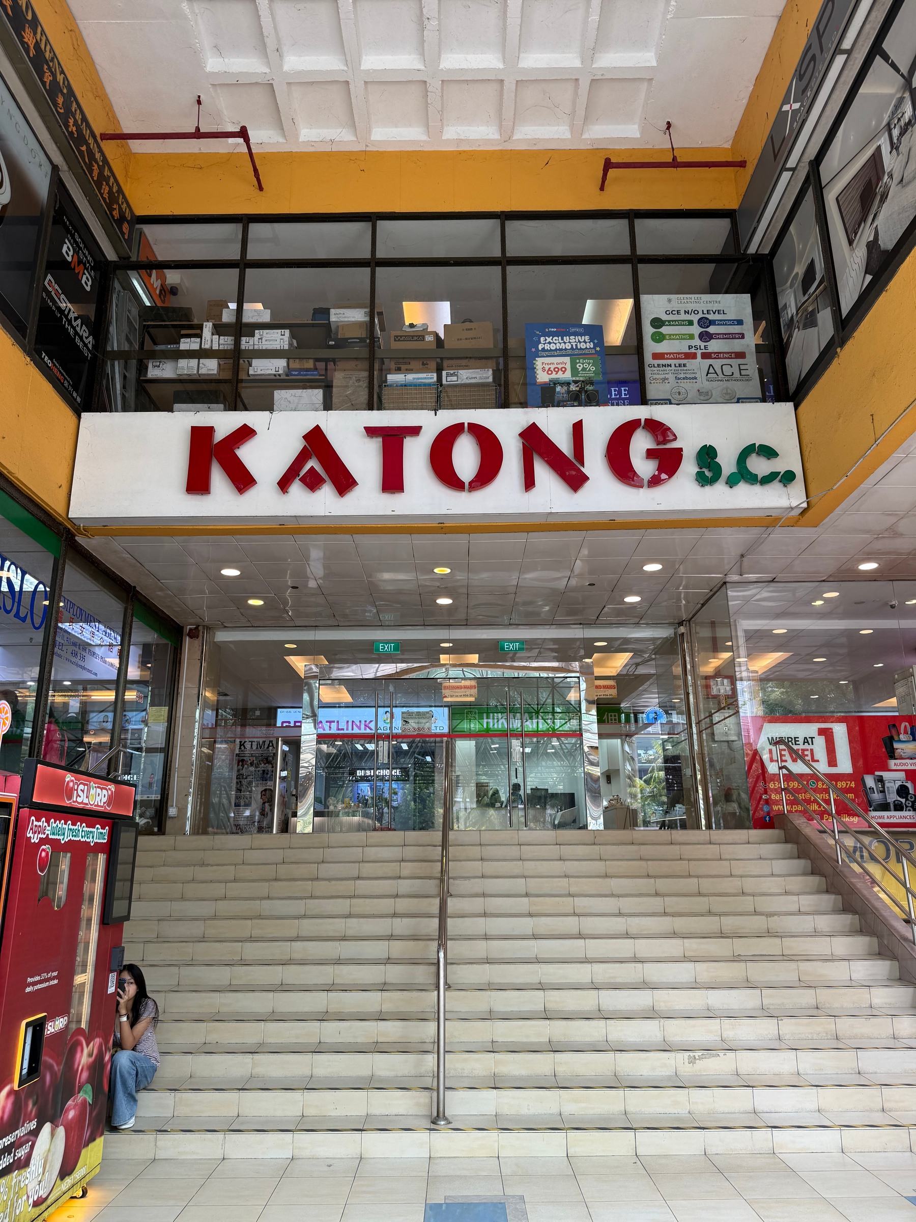 A broad indoor staircase beneath a Katong S.C. sign.