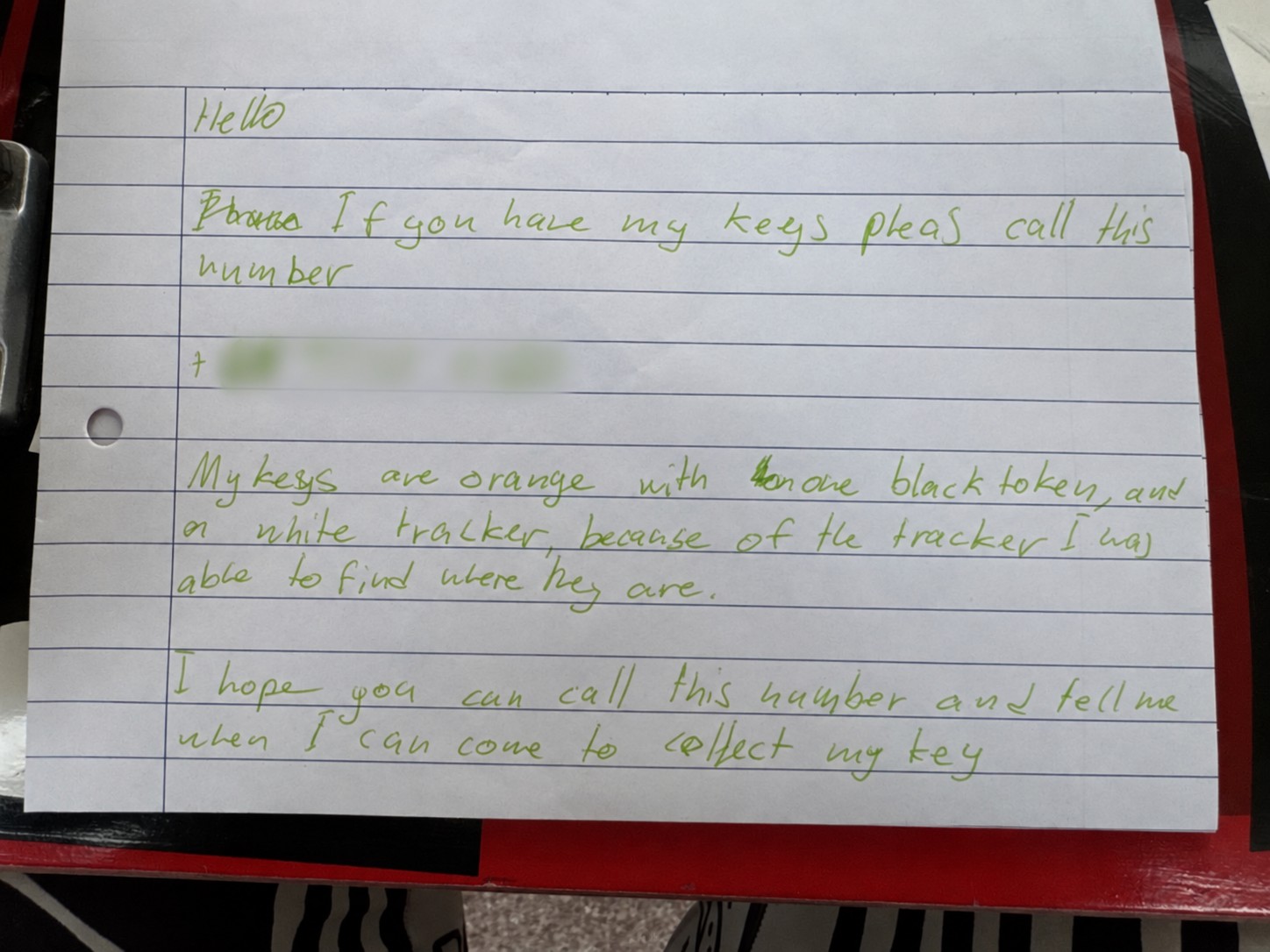 Handwritten note in pale green ink asking the finder to return the keys; contact details obscured
