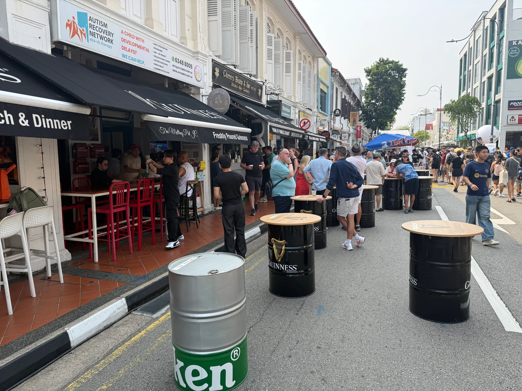 Beer barrels used as standing tables on the pedestrianised road.